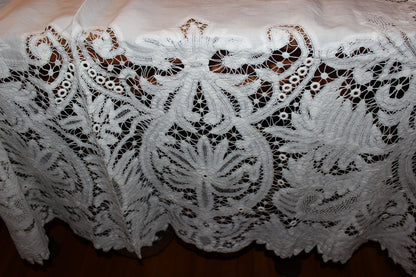 Close-up of intricate white lace fabric on a wooden surface