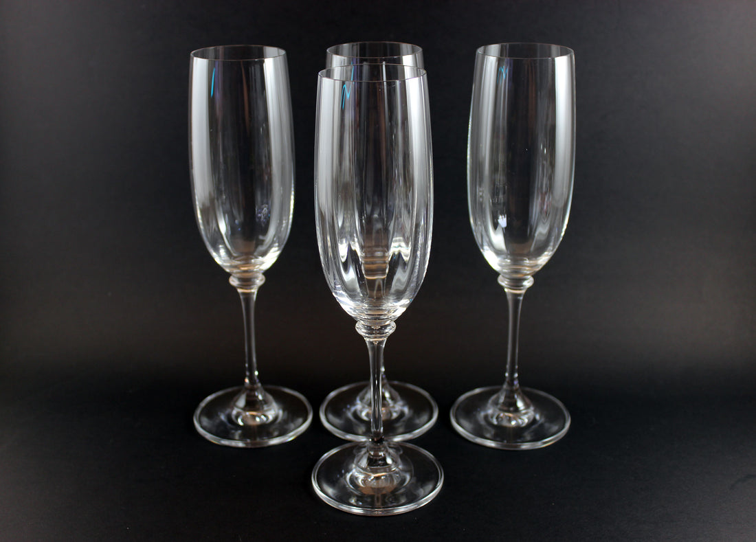 Four Mikasa Stephanie Pattern clear champagne flutes on a black background