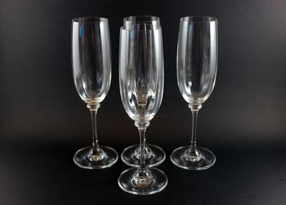 Four Mikasa Stephanie Pattern clear champagne flutes on a black background
