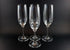 Four Mikasa Stephanie Pattern clear champagne flutes on a black background