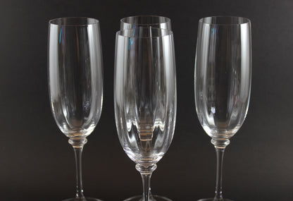 Four Mikasa Stephanie Pattern clear champagne flutes on a black background