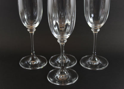 Four Mikasa Stephanie Pattern clear champagne flutes on a black background