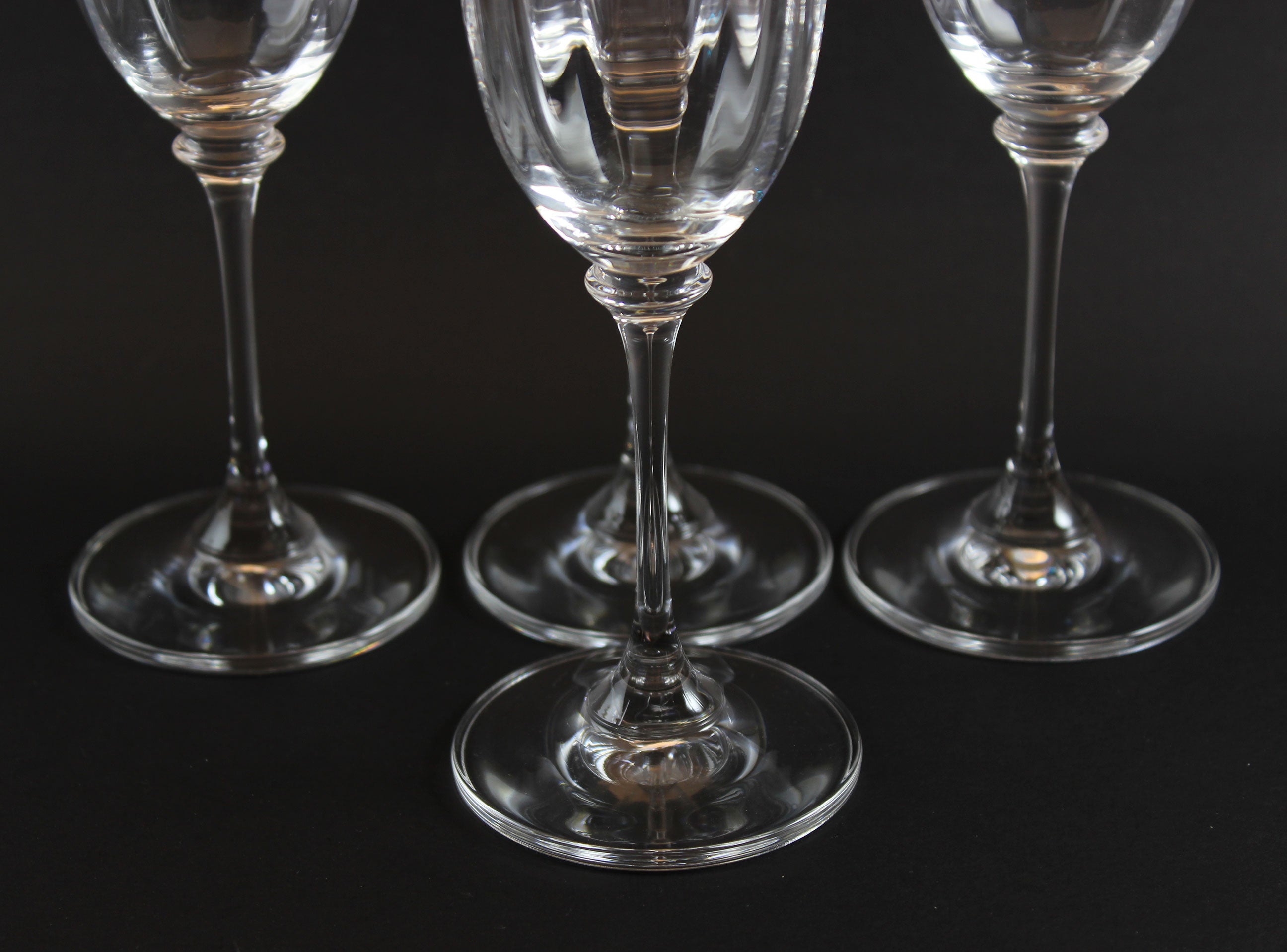 Four Mikasa Stephanie Pattern clear champagne flutes on a black background
