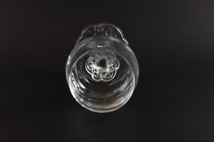 Clear glass object with intricate design on a black background