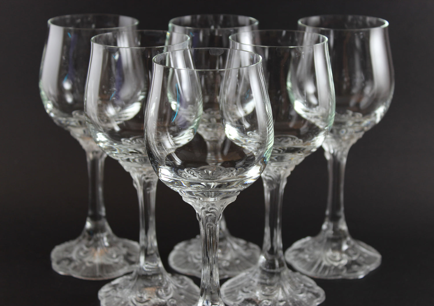 Set of clear glass wine glasses on a black background