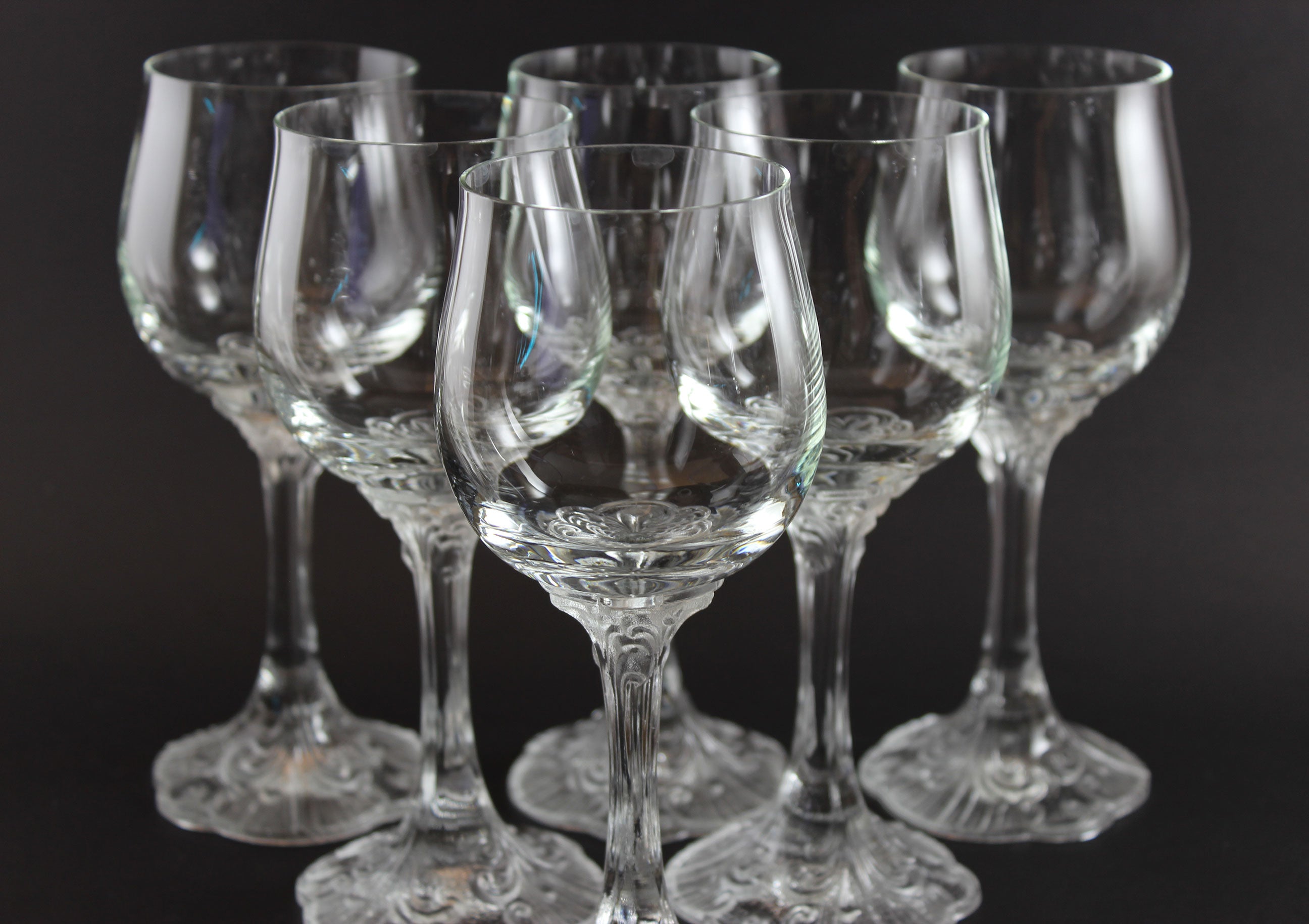 Set of clear glass wine glasses on a black background