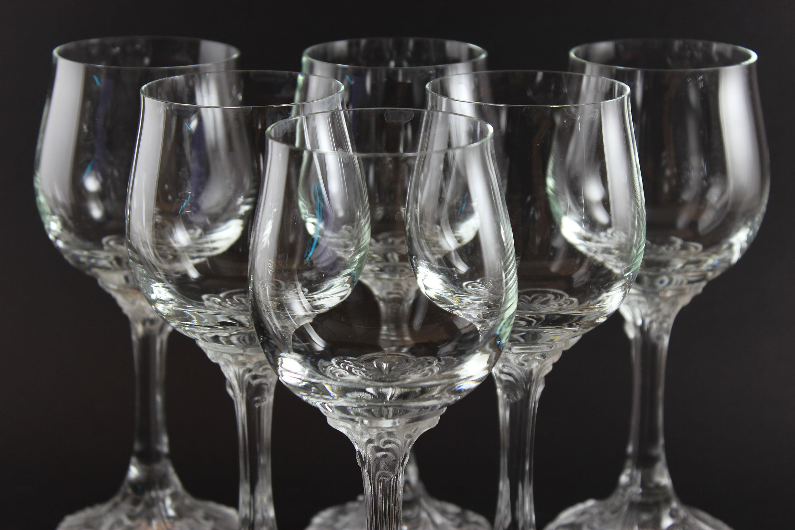 Set of clear wine glasses on a black background