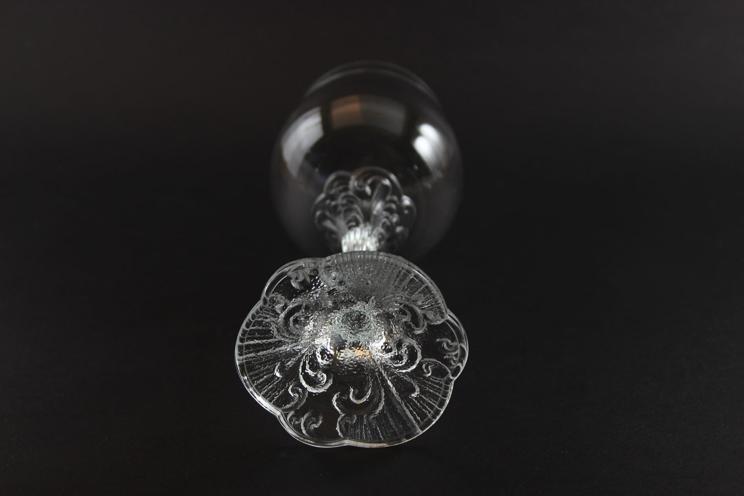 Decorative crystal wine glass with intricate design on a black background