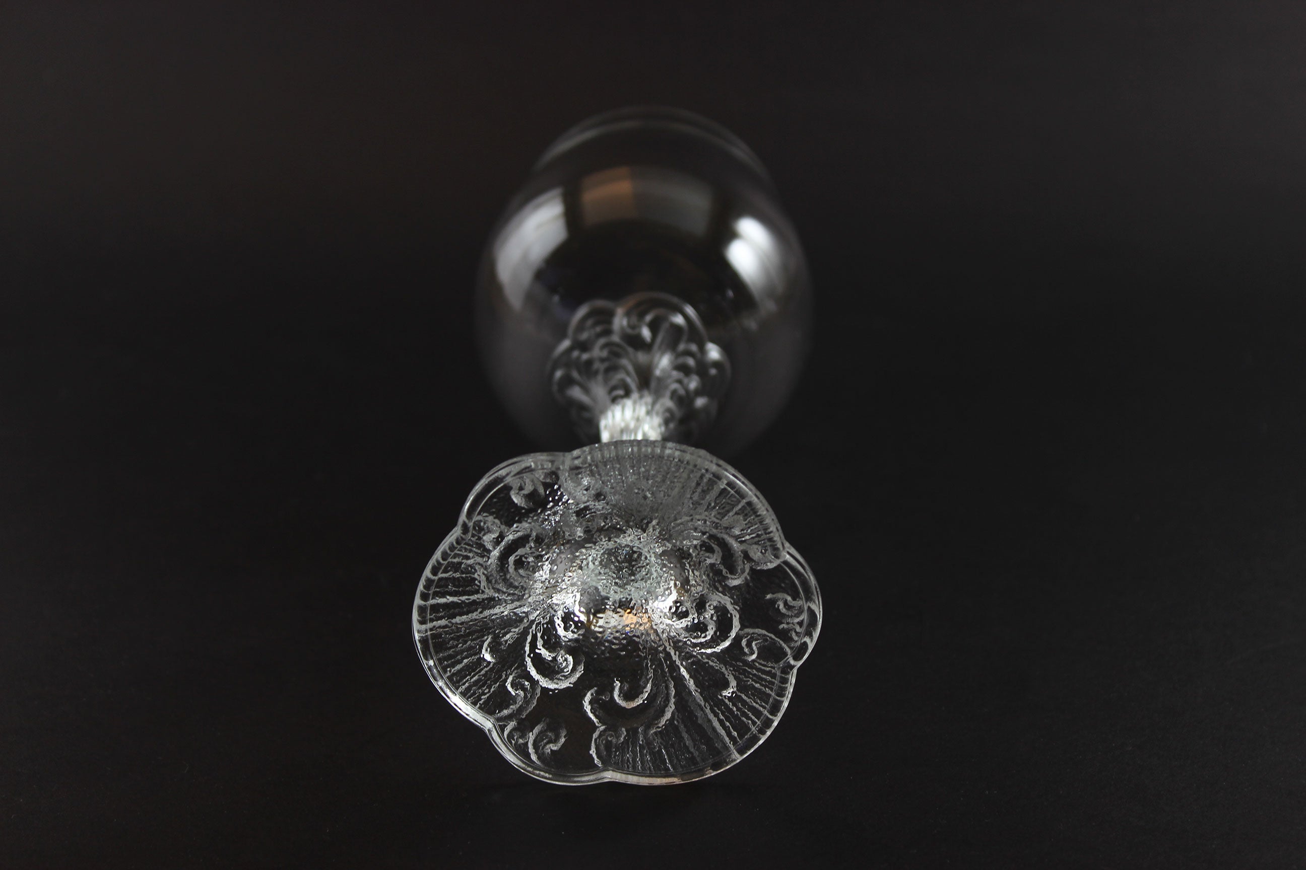 Decorative crystal wine glass with intricate design on a black background