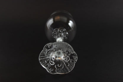Decorative crystal wine glass with intricate design on a black background