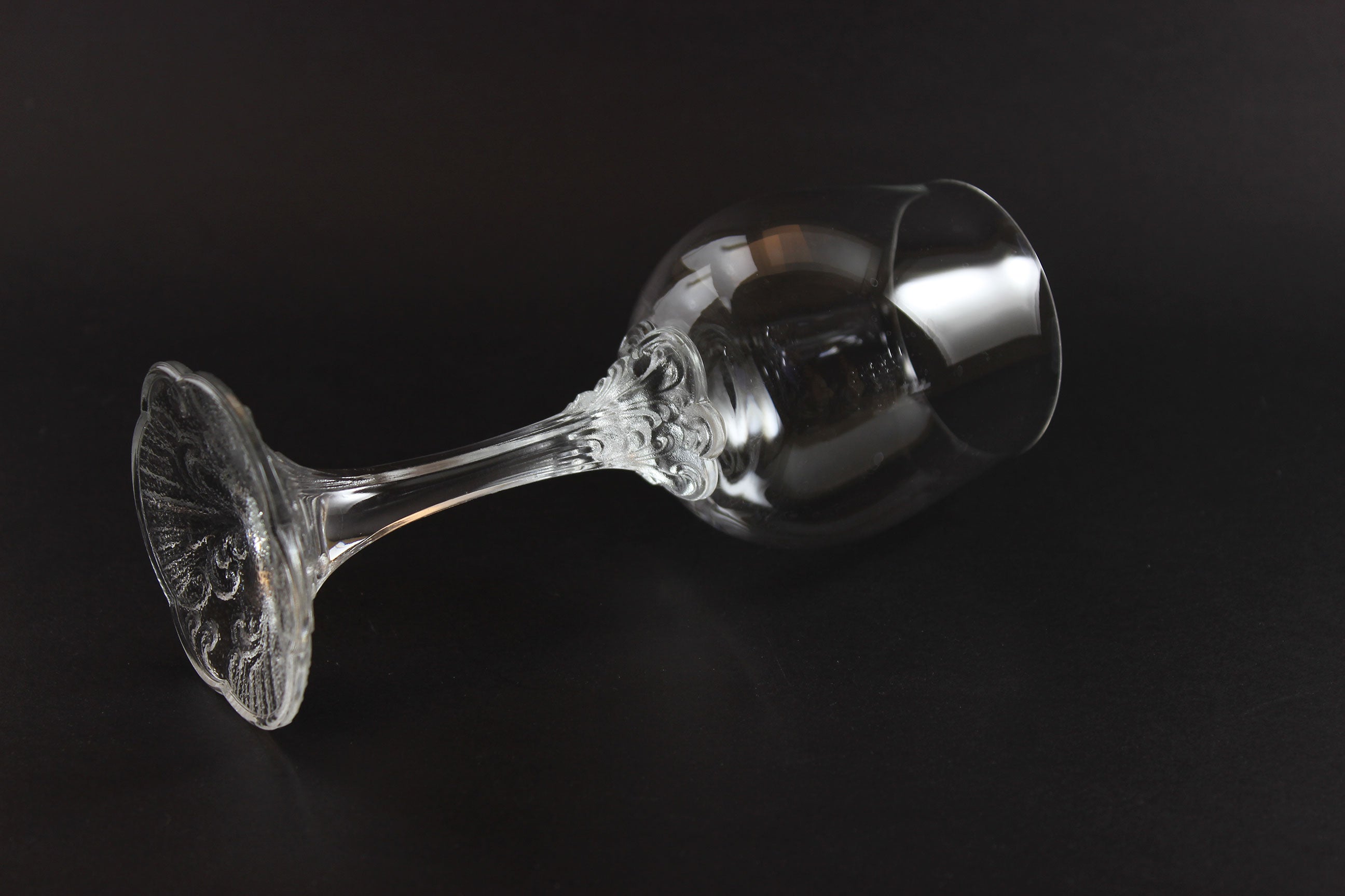 Clear glass goblet with intricate design on a black background