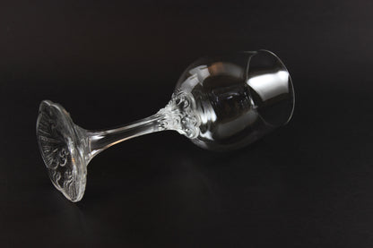 Clear glass goblet with intricate design on a black background