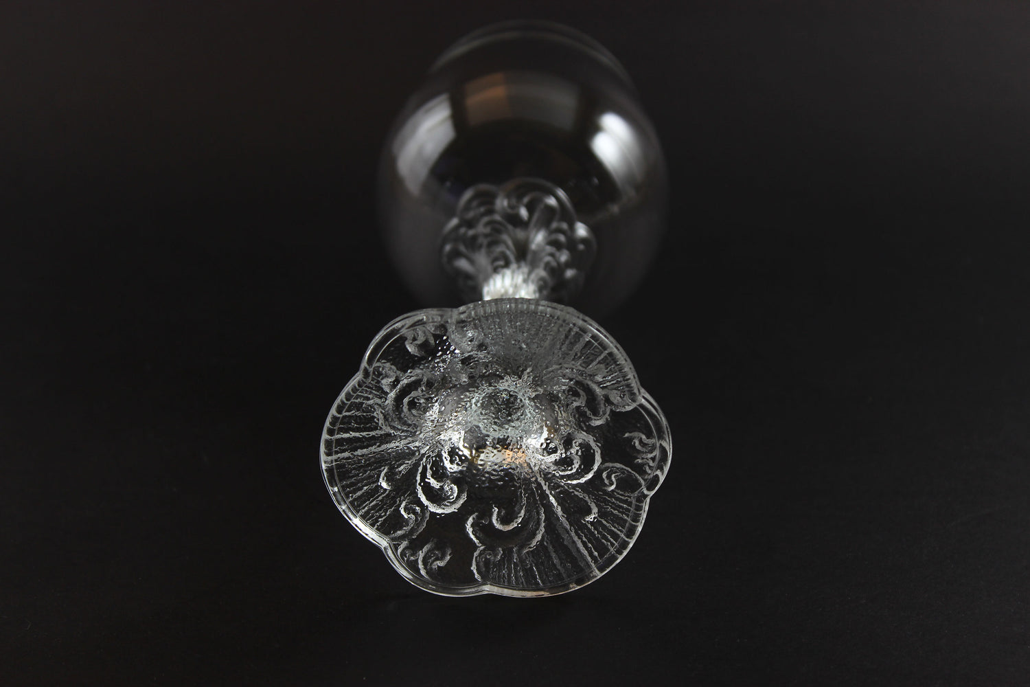 Close-up of a decorative glass object with intricate patterns on a black background
