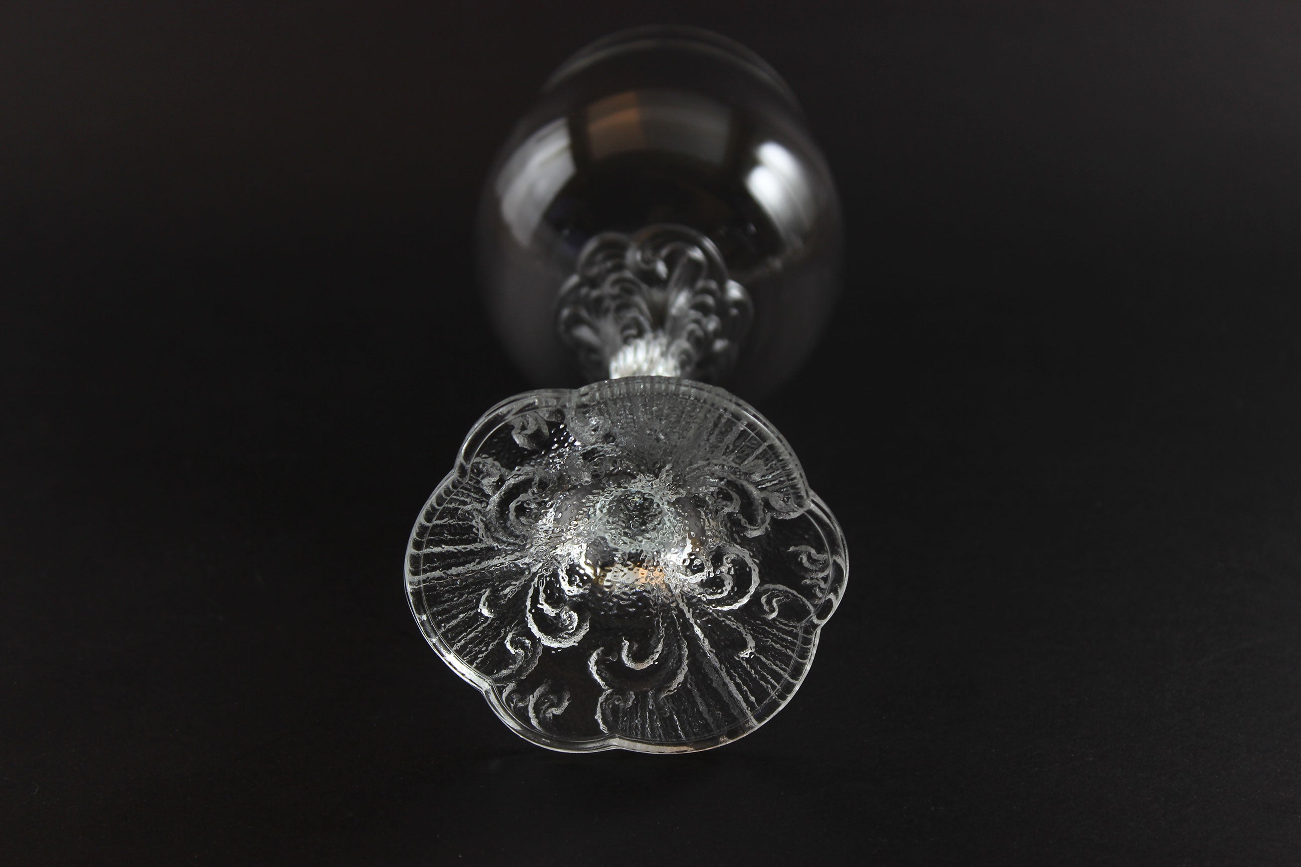 Close-up of a decorative glass object with intricate patterns on a black background