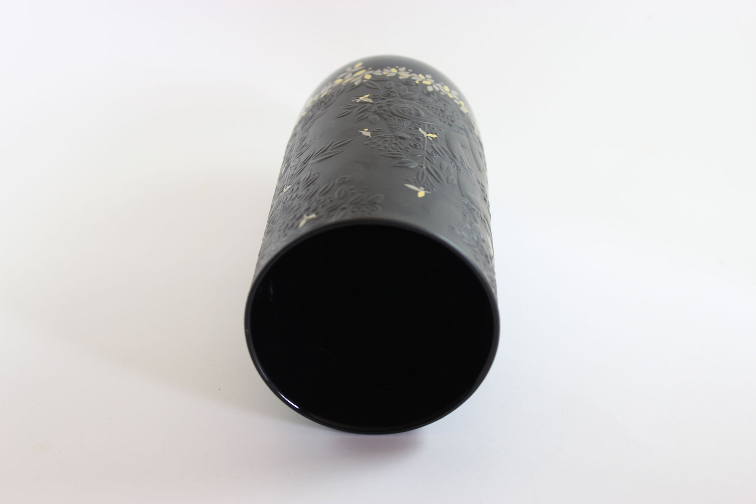 Black cylindrical object with textured surface on a white background
