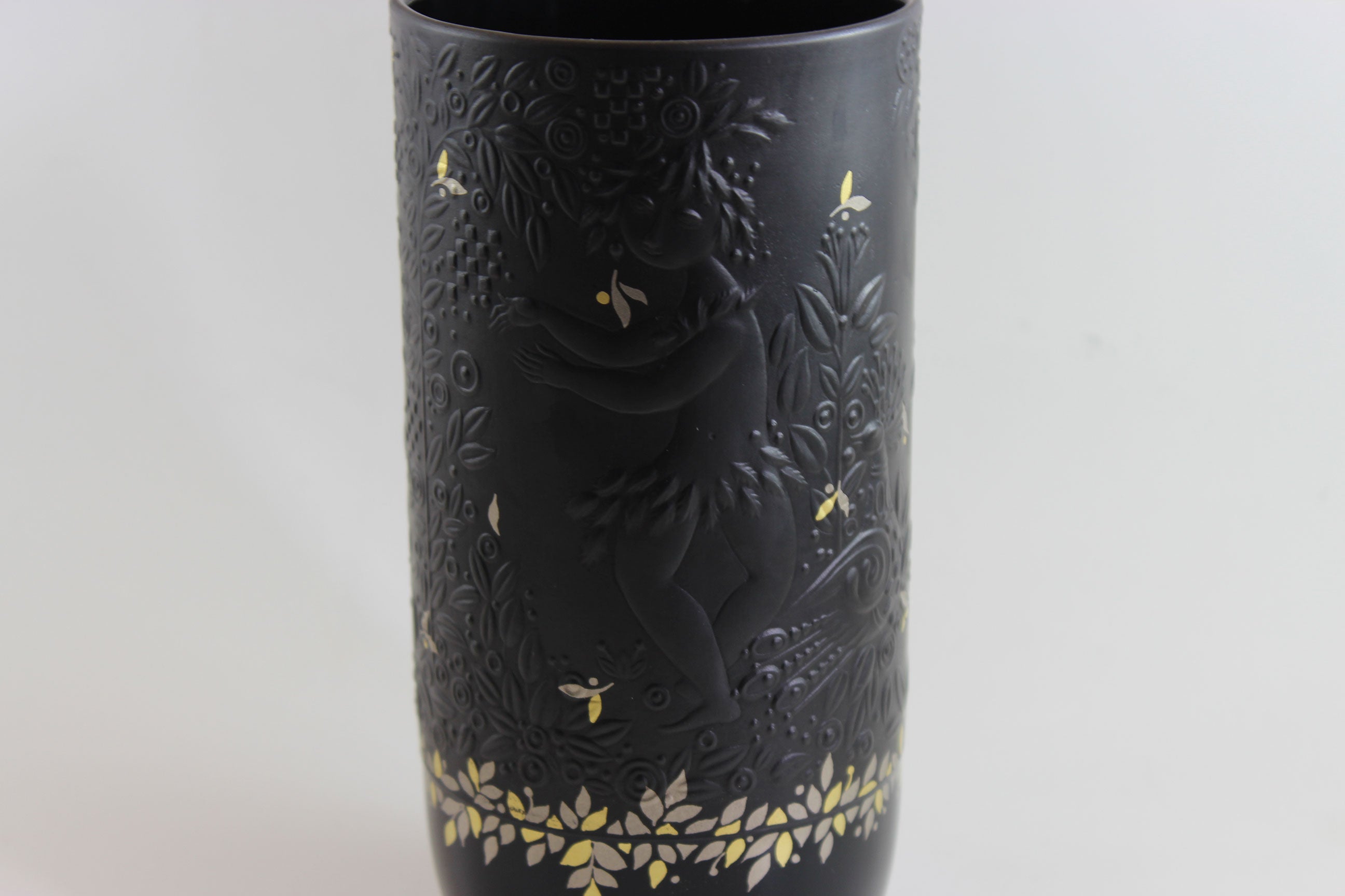 Black vase with gold floral patterns on a white background