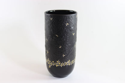 Black vase with gold floral patterns on a white background