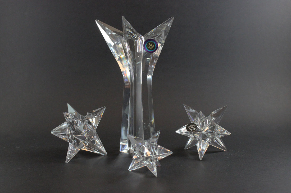 Set of crystal star-shaped candleholders on a dark background