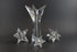 Set of crystal star-shaped candleholders on a dark background