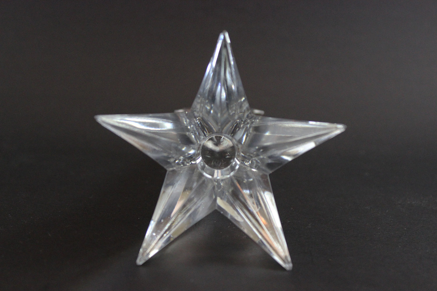 Set of crystal star-shaped candleholders on a dark background
