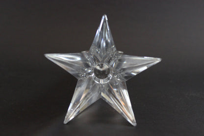 Set of crystal star-shaped candleholders on a dark background