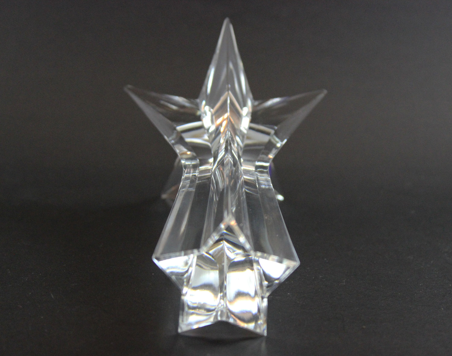 Set of crystal star-shaped candleholders on a dark background