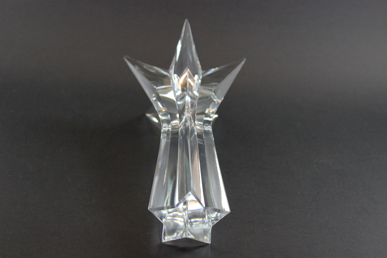 Set of crystal star-shaped candleholders on a dark background