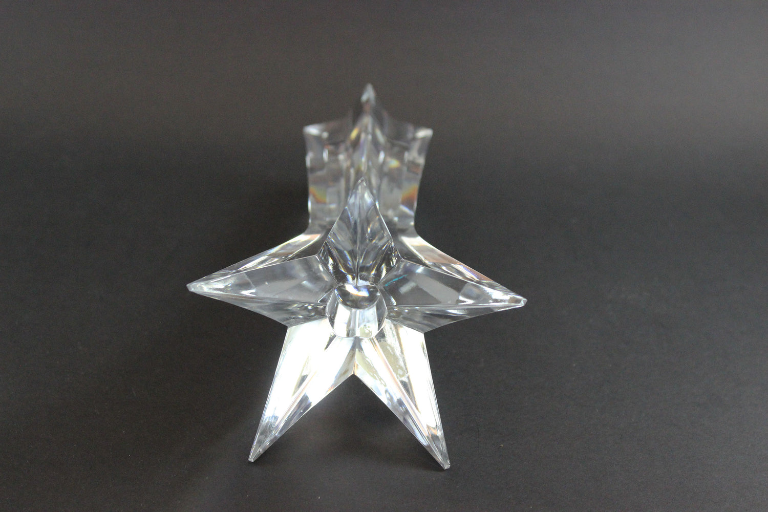 Set of crystal star-shaped candleholders on a dark background