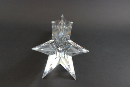 Set of crystal star-shaped candleholders on a dark background
