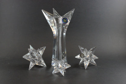 Set of crystal star-shaped candleholders on a dark background