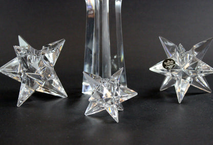 Set of crystal star-shaped candleholders on a dark background
