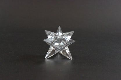 Set of crystal star-shaped candleholders on a dark background