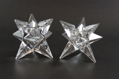 Set of crystal star-shaped candleholders on a dark background
