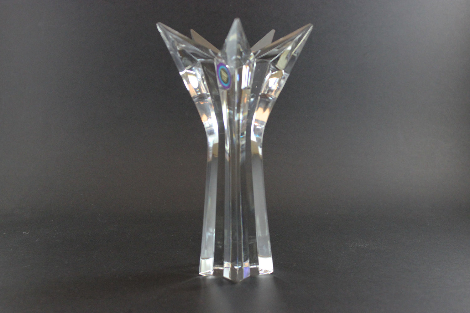 Set of crystal star-shaped candleholders on a dark background