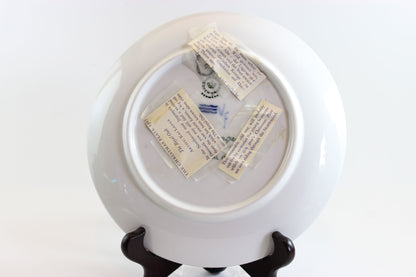 White ceramic plate with text on a stand against a white background