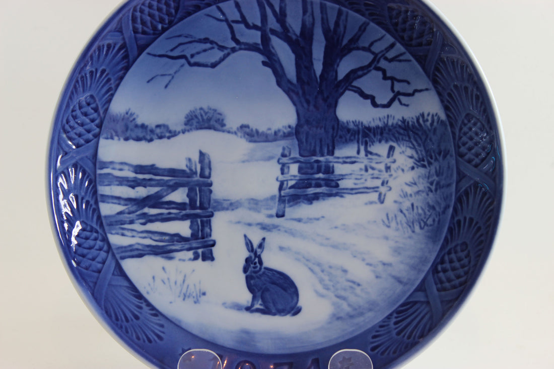 1971 Decorative plate with a blue and white winter scene featuring a rabbit and wooden fence.