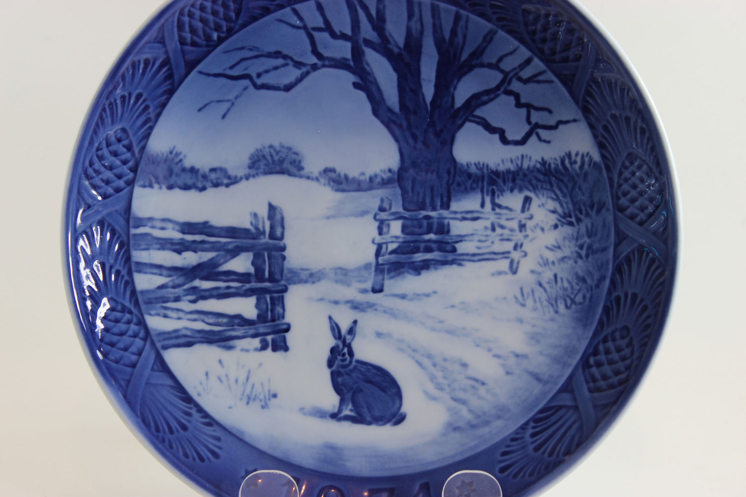 1971 Decorative plate with a blue and white winter scene featuring a rabbit and wooden fence.