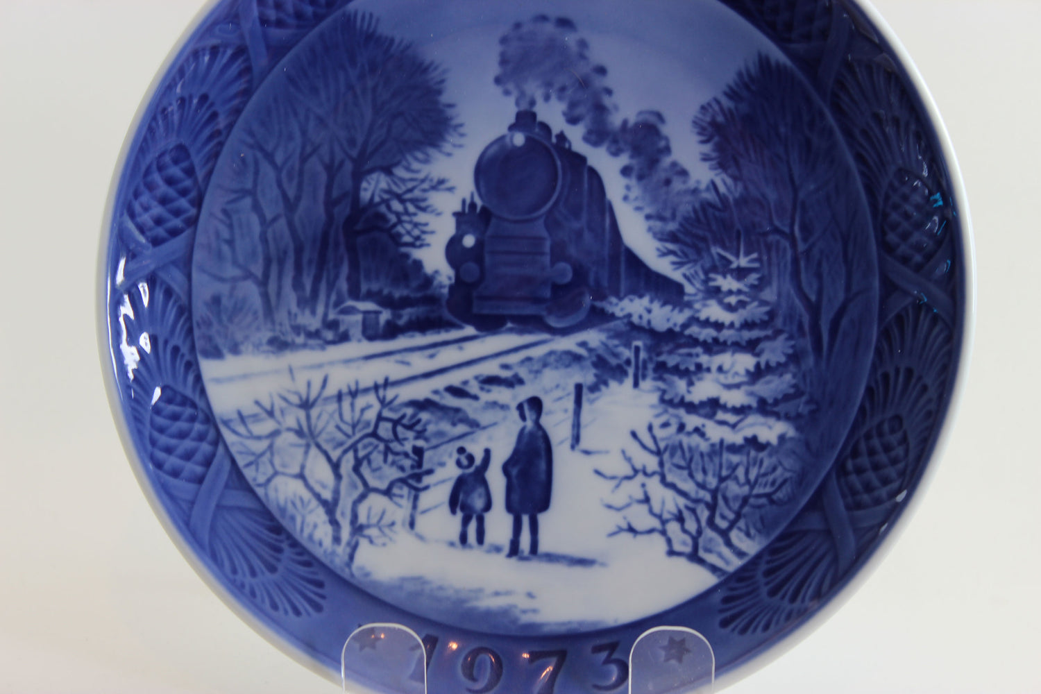 Royal Copenhagen Blue and white ceramic plate with a winter scene of a train and two people, dated 1973.