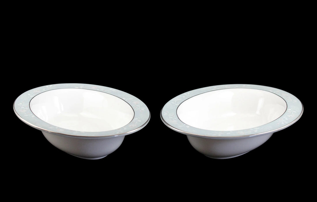 Two Royal Worcester Bridal Rose oval bowls with blue grey band and silver rims on a black background