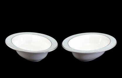 Two Royal Worcester Bridal Rose oval bowls with blue grey band and silver rims on a black background