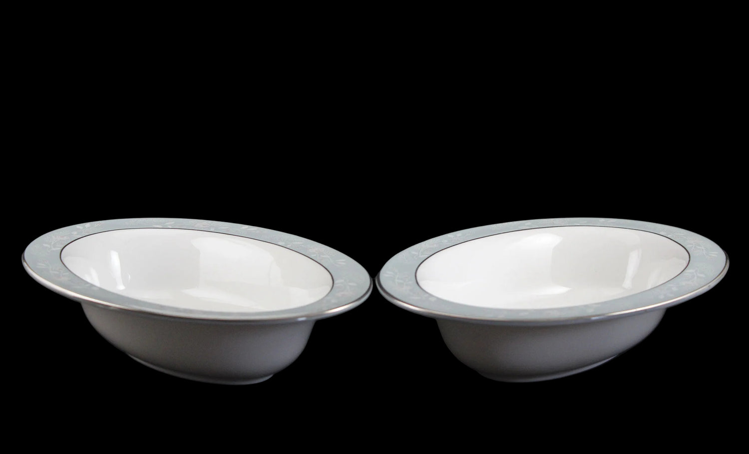 Two Royal Worcester Bridal Rose oval bowls with blue grey band and silver rims on a black background