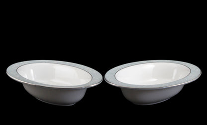 Two Royal Worcester Bridal Rose oval bowls with blue grey band and silver rims on a black background