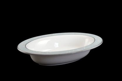 Royal Worcester Bridal Rose oval bowl with blue grey band and silver rims on a black background