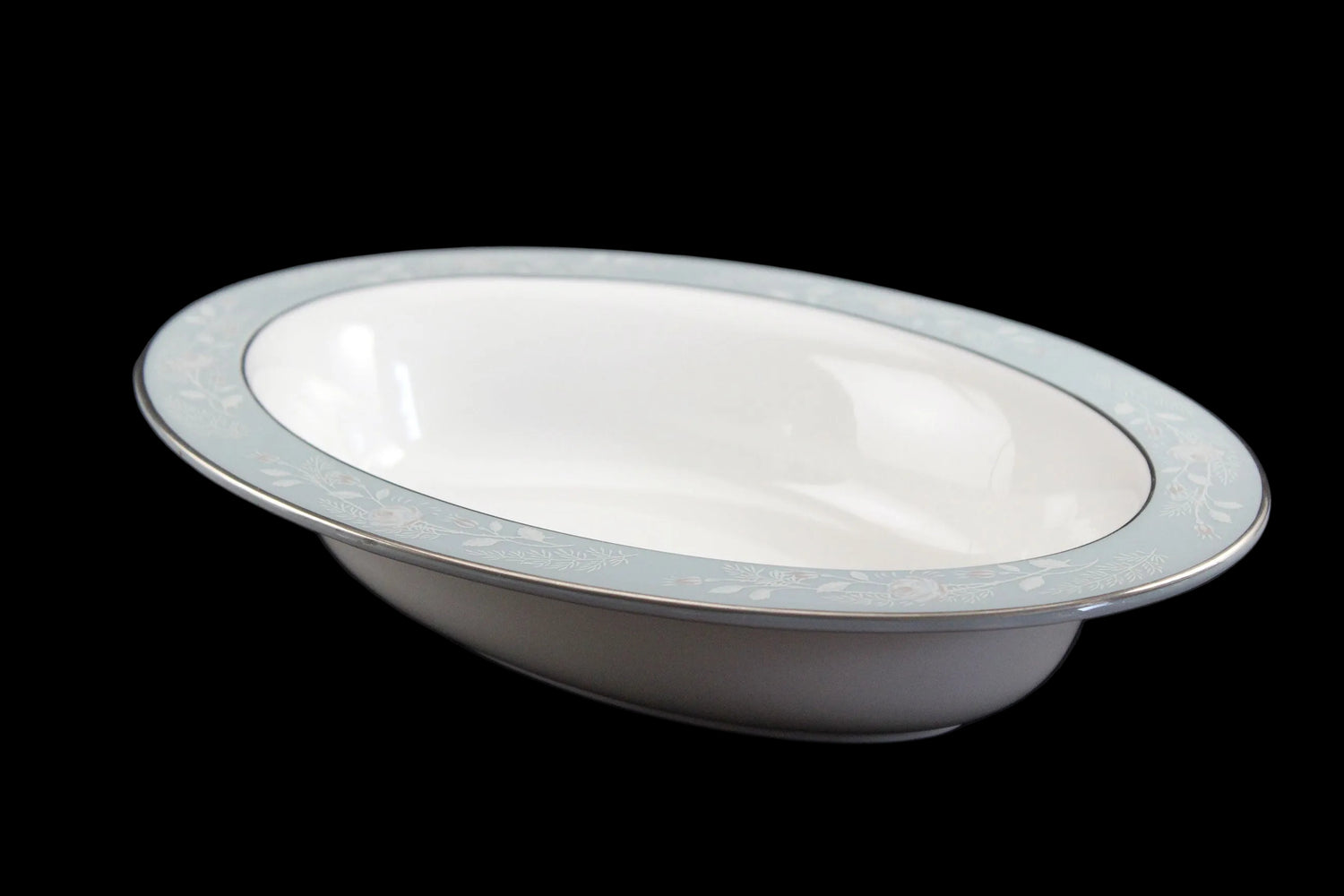 Royal Worcester Bridal Rose oval bowl with blue grey band and silver rims on a black background