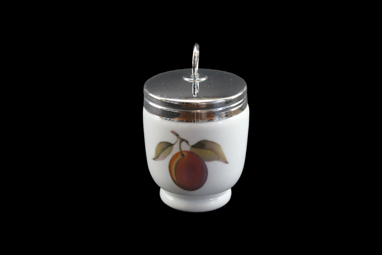 White ceramic jar with silver lid and fruit design on a gray background