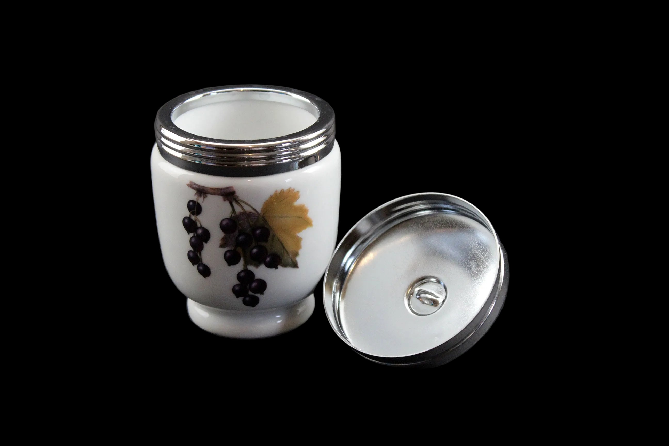 White ceramic container with silver lid on a dark background