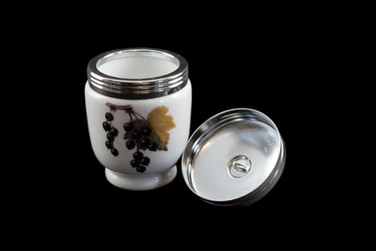 White ceramic container with silver lid on a dark background