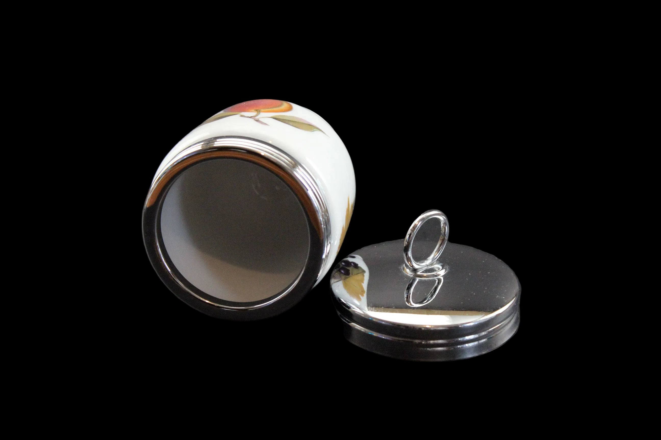Ceramic egg coddler with decorative lid on a black background
