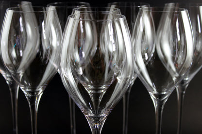Row of clear wine glasses on a dark background