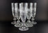 Set of six crystal glasses with diamond cut pattern on a black background